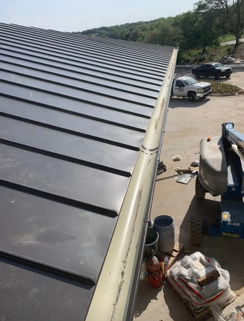 Standing seam panel and gutter detail on a metal roofing jobsite in Munster